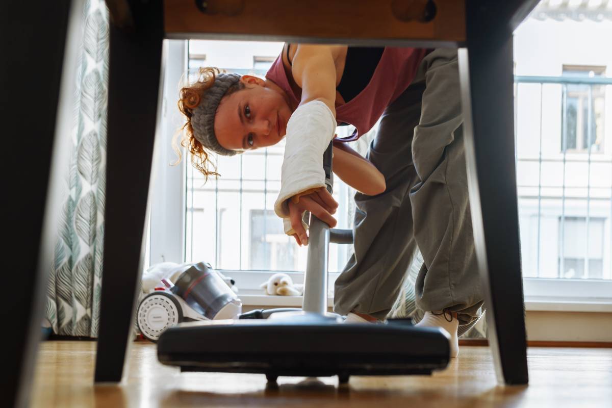 Une femme qui passe l'aspirateur sous la table