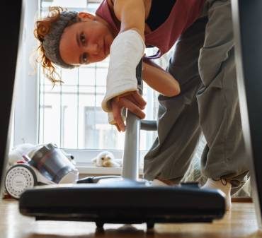 Une femme qui passe l'aspirateur sous la table