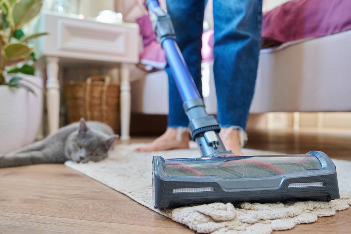 Une femme qui passe l'aspirateur sur un tapis