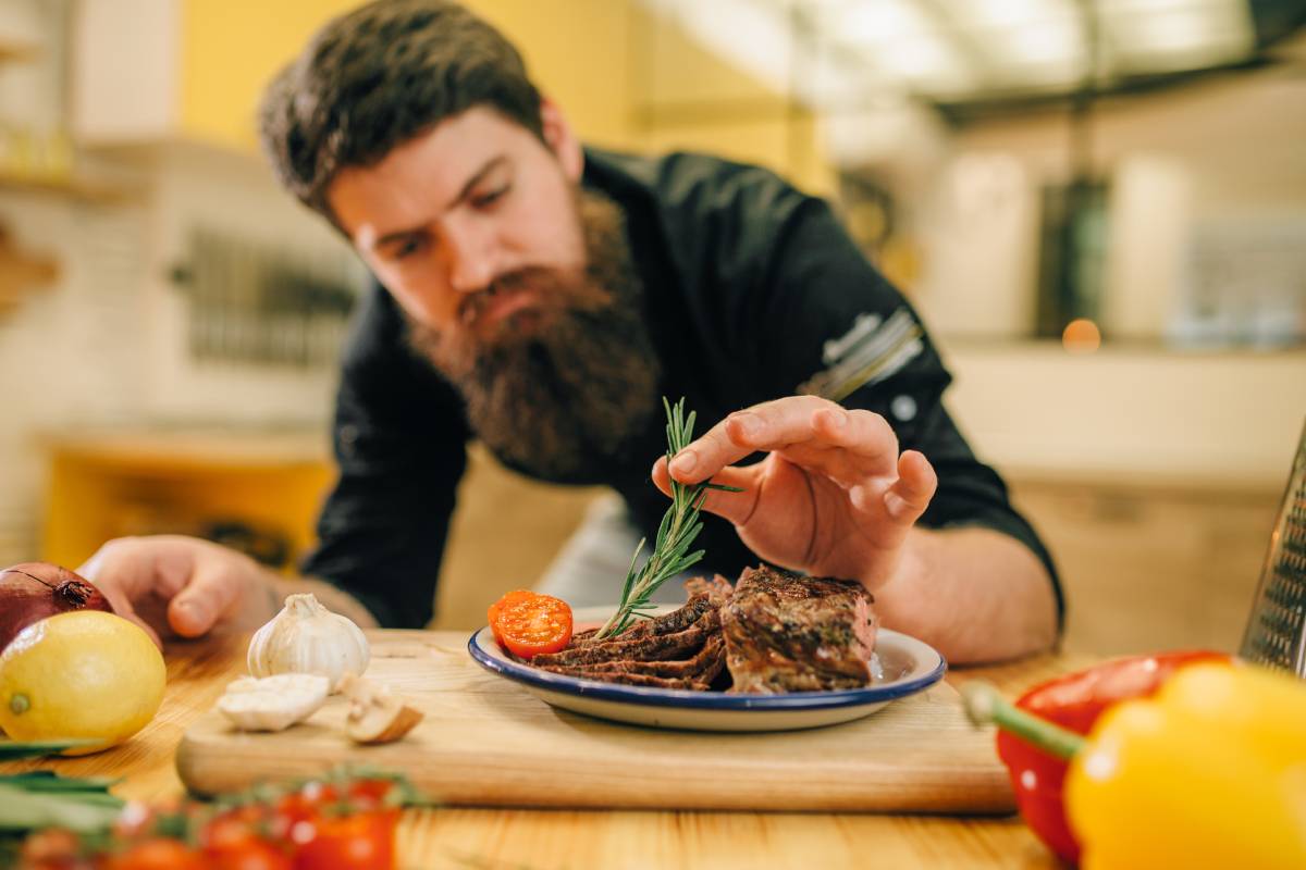 Un chef de cuisine qui décore une assiette