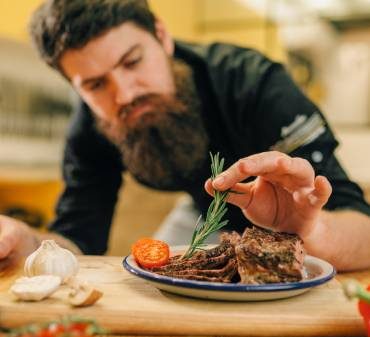 Un chef de cuisine qui décore une assiette