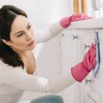 Une femme qui nettoie un meuble