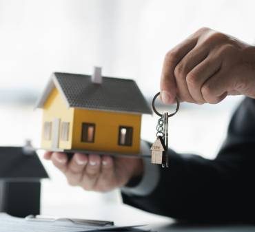 Un agent immobilier en train de donner des clés de maison