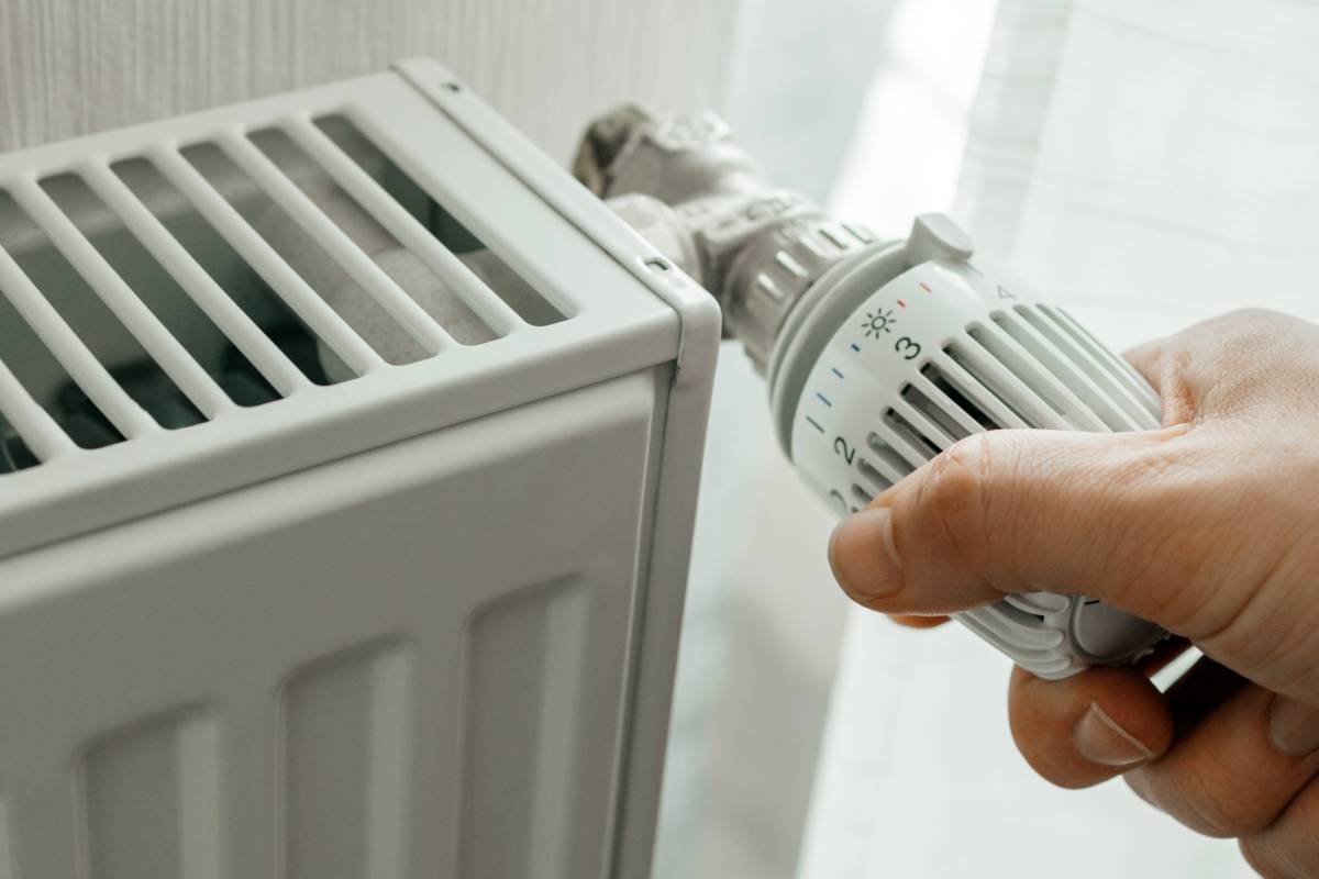 Un homme qui augmente la température du radiateur