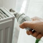 Un homme qui augmente la température du radiateur