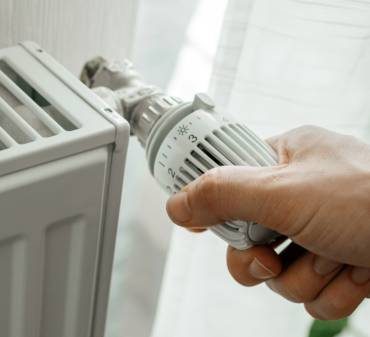 Un homme qui augmente la température du radiateur