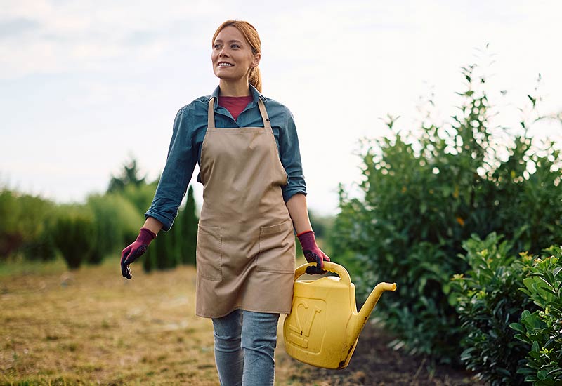 Femme paysagiste entretient l'extérieur.